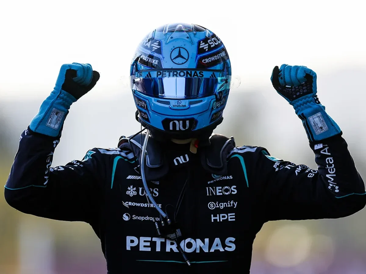 George Russell celebrates his 2026 Azerbaijan Grand Prix victory in Mercedes racewear and helmet.