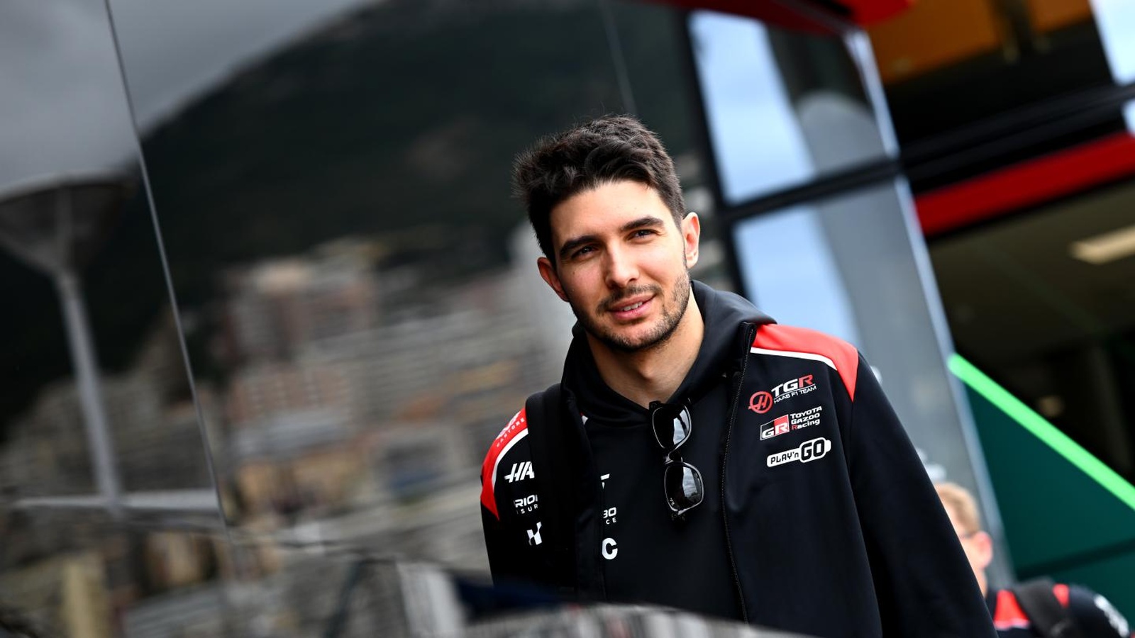 Esteban Ocon wearing TGR Haas F1 Team clothing in the Formula 1 paddock.